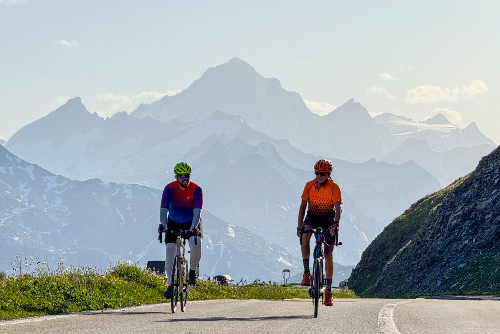 Pair of cyclists climbing Furka Pass in Swiss Alps with Marmot Tours