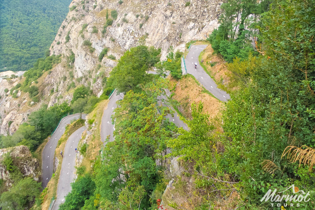 Cyclists climbing hairpin bends of Lacets du Montvernier in French Alps cycling holiday with Marmot Tours