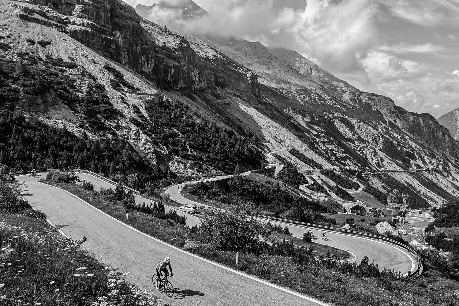 Black and white image of cyclists climbing Passo dello Stelvio on Marmot Tours full support cycling holiday