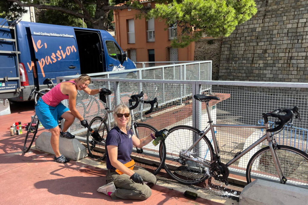 Two Marmot Tours guides cleaning hire bikes on Raid Pyrenees cycling challenge