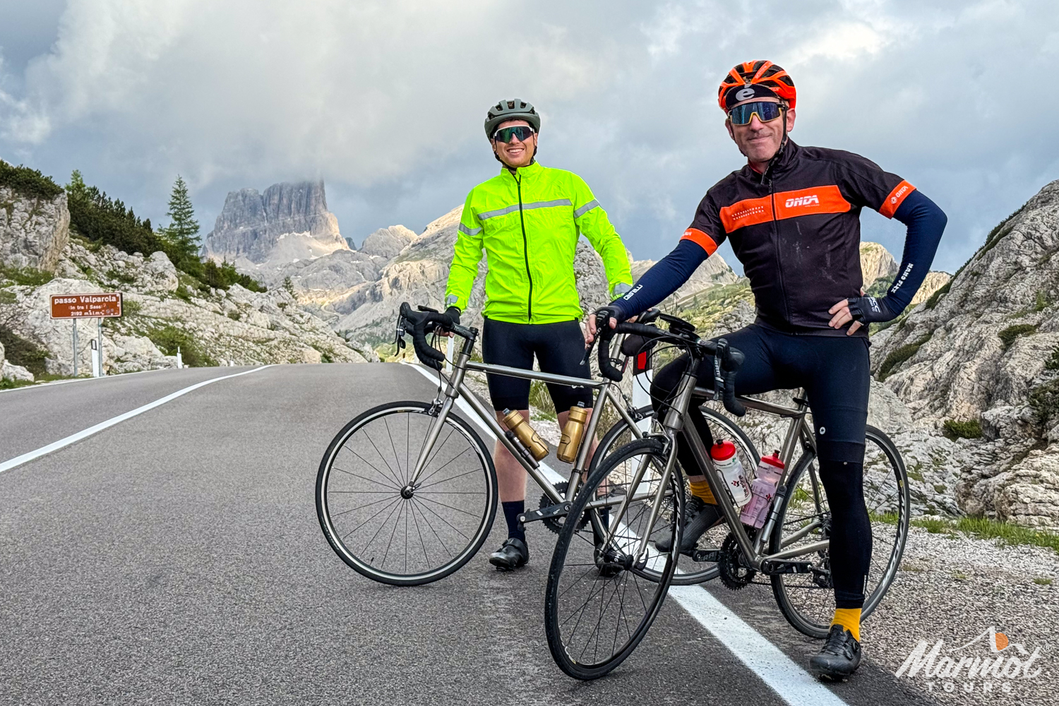 Pair of cyclists posing with Marmot Tours hire bikes at Passo Valparola