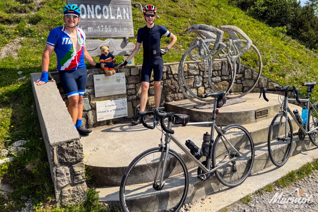 Pair of cyclists at Monte Zoncolan summit with two Marmot Tours hire bikes