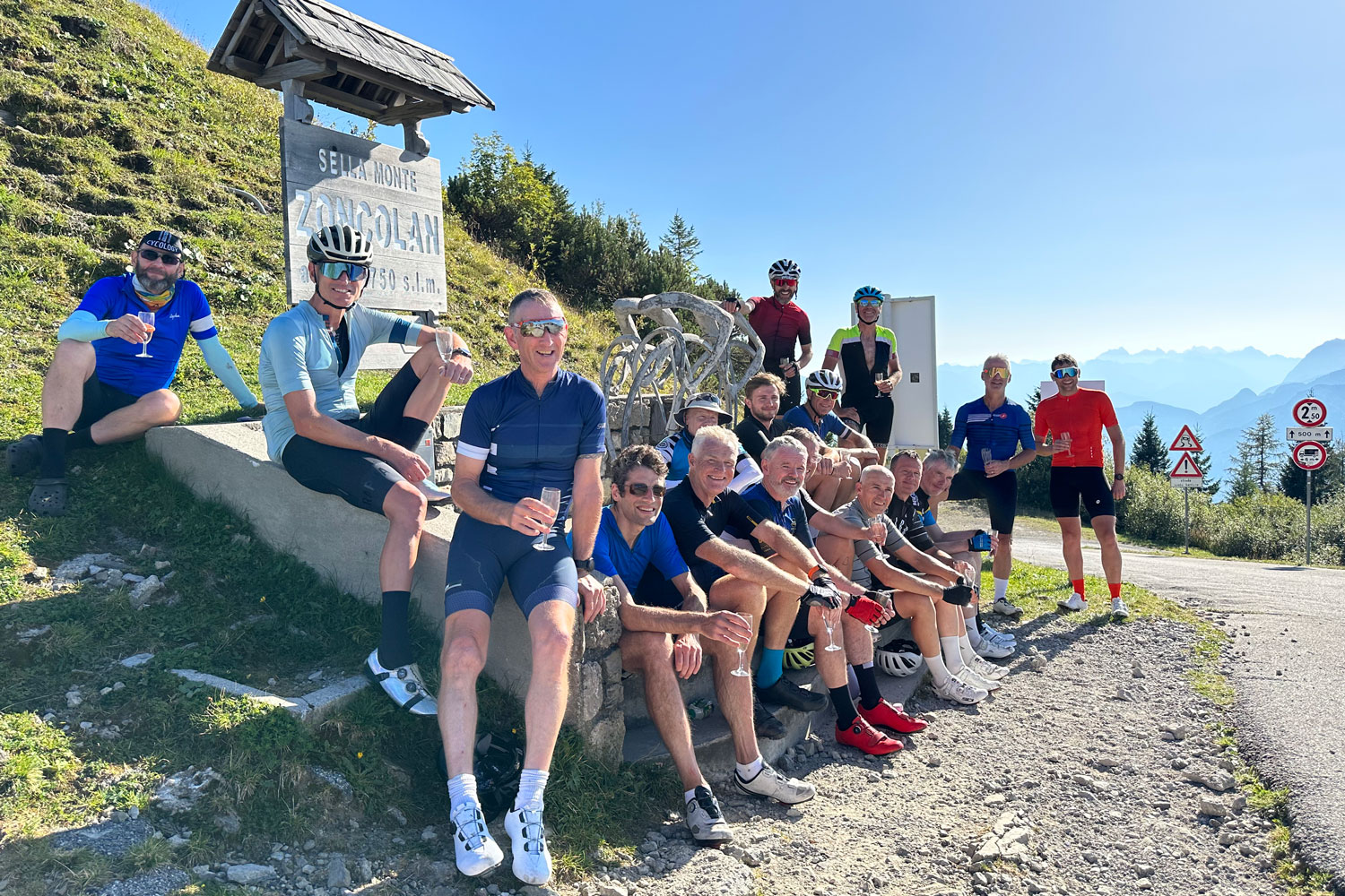 Group of cyclists celebrating at Raid Dolomites finale on Monte Zoncolan with Marmot Tours