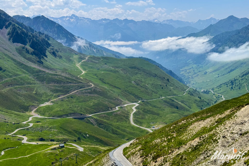 Winding road in French Pyrenees with mountains skyline and green valley on Marmot Tours road cycling holiday